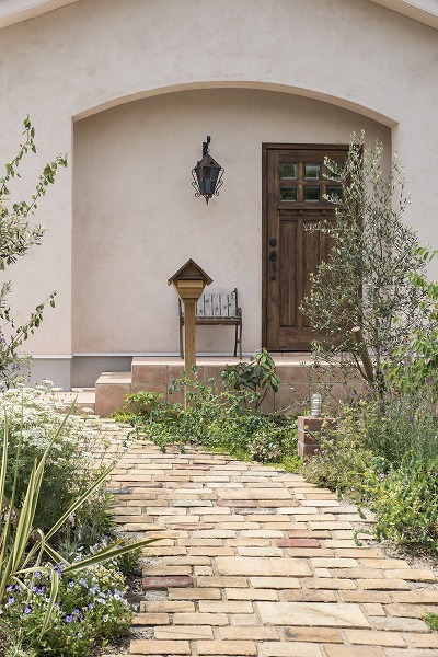 なだらかな丘の中腹に建つ家は、家と外構が一体となってオシャレな雰囲気を醸し出しています。ガーデニングも四季折々楽しむことができる。