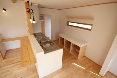 ガラスのペンダントライトや、タイルを貼った造作の棚が可愛いキッチンコーナー