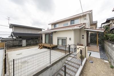 外観は白壁とオレンジ色の屋根で洋風に。ガレージは掘り込みタイプ。広いお庭で家庭菜園も愉しめる。