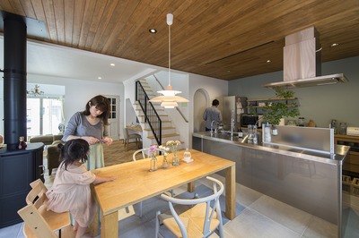 キッチンはオシャレなオールステンレス製。キッチンに床が合うようにタイルは控えめの色合いに。対面には造作のカウンター収納をつくり、お気に入りのミーレの食洗器を入れた。