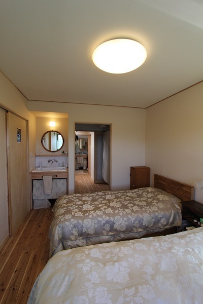 まるでホテルの様な主寝室。一角にある洗面台の鏡は以前玄関にあったものを再利用。 まるでホテルの様な主寝室。一角にある洗面台の鏡は以前玄関にあったものを再利用。