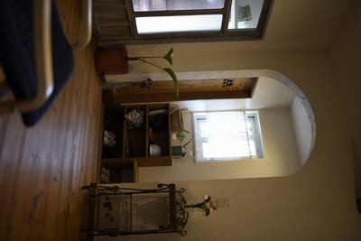 インディゴブルーの扉が印象的な玄関には飾り棚やお母様のアトリエに直行できるドアを設置。リビングへのくぐり戸はアーチ状に