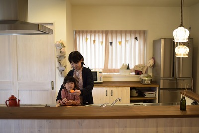 リビングダイニングに目が行き届くアイランドキッチン。背面収納とパントリーは造作。収納するアイテムのサイズに合わせて設計したので使いやすく、常にすっきりした状態をキープできる。