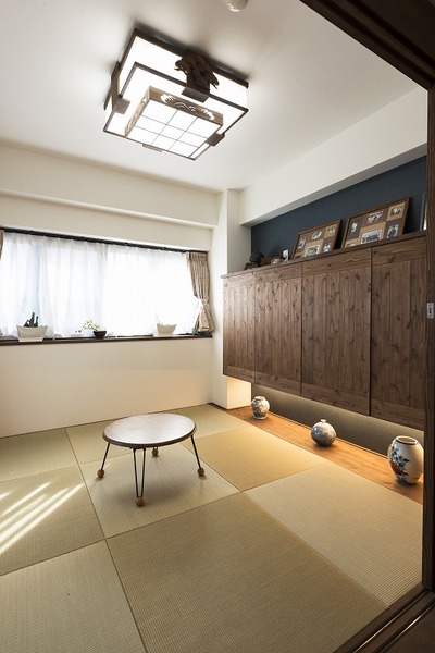 ダイニングと繋がる和室。布団の収納する扉を無垢材で造作し、リビングから見えても違和感がないようにデザインに。天井に見えるのが、奥様のご実家から取り寄せたかった懐かしい照明。