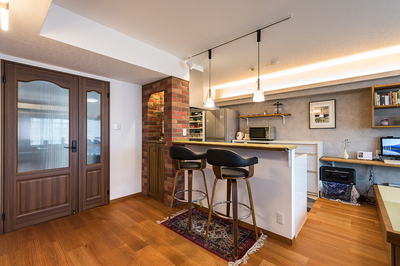 狭くて暗い廊下を広げて、憧れの親子ドアを設置。どこのマンションにも在りがちな縦長いLDKをL型に間取りを変えてみました。奥まったキッチンを手前に出して、奥にパントリースペースを設けました。これからは会話しながら料理もできるでしょう。