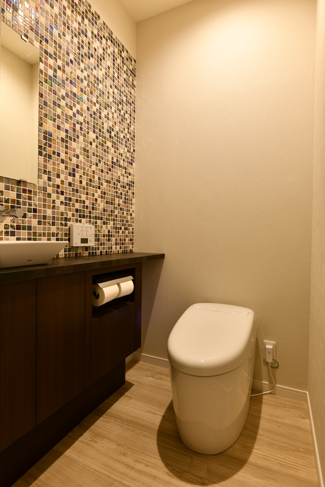 トイレは自動水栓にし手洗いカウンターはオリジナル制。煌めくモザイクタイルを貼っています。