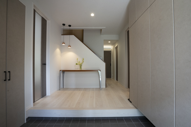 元々広かった玄関は、タイルをそのまま活用。
物置にはお孫さんのベビーカーなどを収納している。
正面の間接照明は奥様のアイディア。