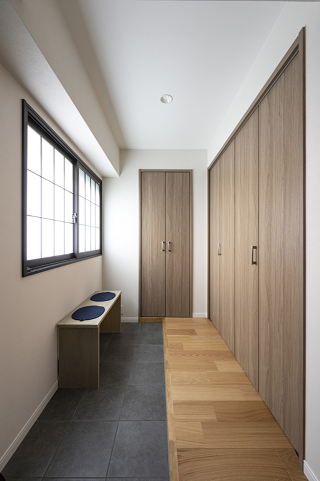 戸建てのように広く明るい玄関。
造作のベンチは靴を履くときだけでなく荷物置きとしても活躍しそう。
内窓には障子デザインを採用することで、落ち着きのある『和』の雰囲気に。