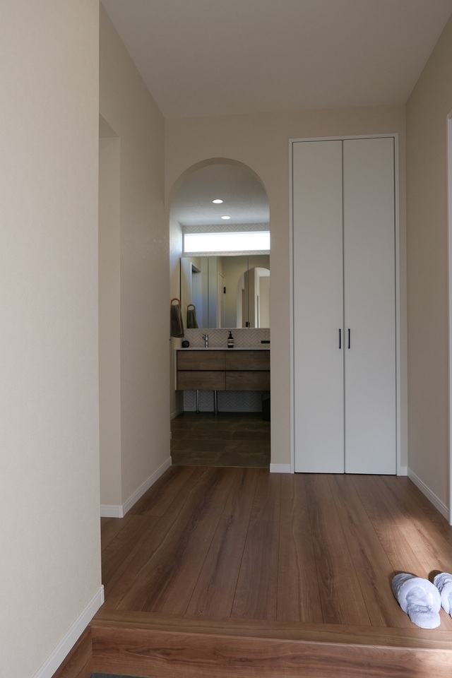 ご希望だったアーチ開口は、玄関ホールからの洗面所入口に。
建具をつけないことで、奥行と開放感のある玄関ホールになり、洗面化粧台上部に設けたFIX窓のおかげで明るさも確保できました。