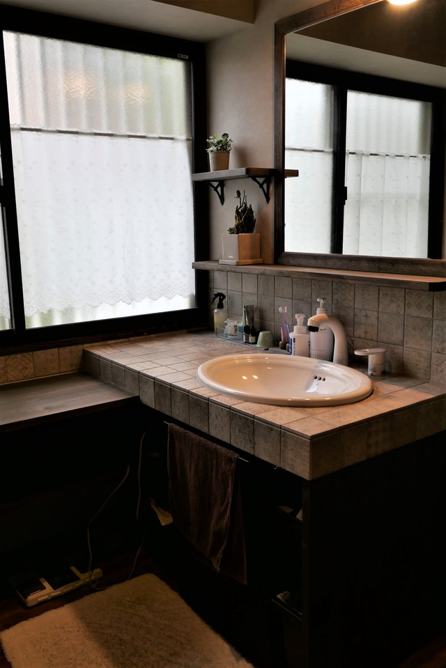 段差をつけた造作洗面台は椅子を置いてスキンケアができるようにし、その横に洗濯機や下着やタオルを入れる収納も備えた機能的な空間になっています。