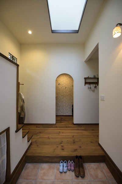 天窓から自然光が差し込む明るい玄関。正面の収納スペースへの入り口にはアールをつけて優しい表情に。 天窓から自然光が差し込む明るい玄関。正面の収納スペースへの入り口にはアールをつけて優しい表情に。