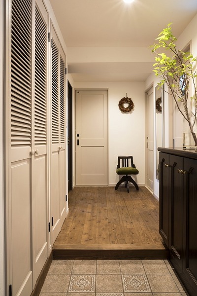 クラシカルなタイルと靴箱のデザインを生かした玄関。左側に大容量の収納を設置。 クラシカルなタイルと靴箱のデザインを生かした玄関。左側に大容量の収納を設置。