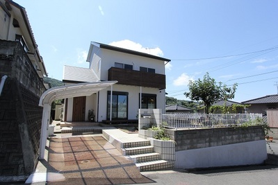 外観はリシン吹付け。<br />
既存のアルミバルコニーに木を貼ってアクセントをつけました。